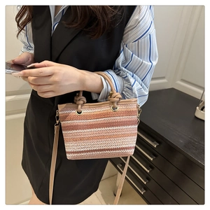 Détail du sac seau tissé ethnique avec poignée en cuir et accessoires dorés