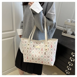 Detail of canvas tote bag featuring cute pink bear patterns and slim shoulder straps