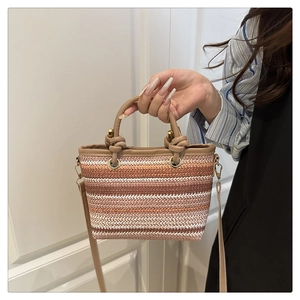 Vue détaillée du sac seau tissé avec rayures orange et marron et ferrures dorées
