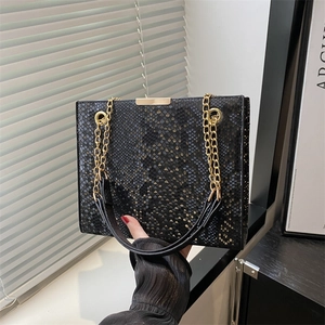 Fashionable black snake-print crossbody bag with golden chain straps and lock closure