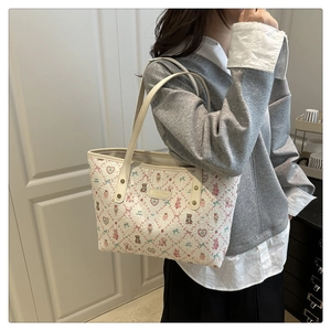 Detail of white tote bag with cute cartoon animal prints and golden hardware accents