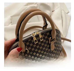 Detailed close-up of smooth gold metal zippers on a vintage patterned shell handbag