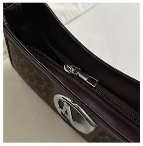 Detail showing high-quality smooth metal zipper and monogram canvas of the shoulder bag
