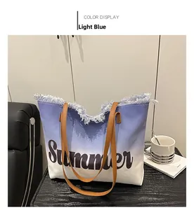 Detail of light blue gradient canvas tote bag with Summer text and leather straps