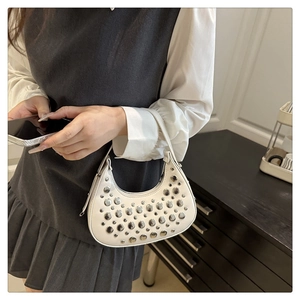 Detailed view of white hobo bag with silver metallic studs and integrated strap