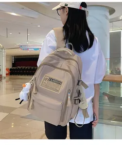 Close-up of khaki nylon backpack with Fashion embroidery and white duck plush keychain