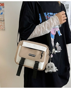 Detail of color-block canvas crossbody bag featuring quick-release buckles and octopus charm
