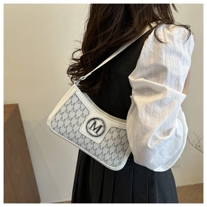 Detail of grey M letter prints and silver metal logo on white leather shoulder bag