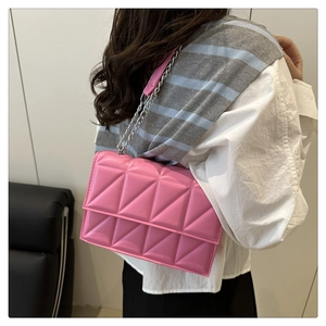 Vue détaillée du sac bandoulière rose matelassé avec une chaîne en métal argenté