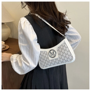 Close-up of white shoulder bag with grey M-pattern print and silver metallic logo