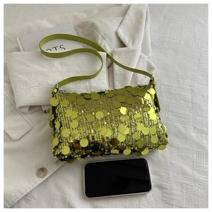 Detail of neon green sequin crossbody bag with smartphone for size reference