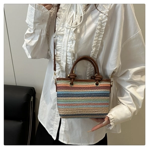 Détail du sac seau bohème en paille avec rayures colorées et poignées en cuir