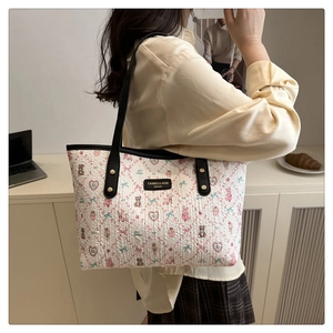 Detail of off-white tote bag with embossed cartoon bears and textured fabric finish
