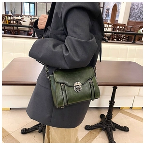 Retro dark green oil wax leather crossbody bag with vintage lock on a model in a cafe