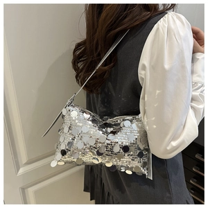 Detail of silver sequined shoulder bag with reflective mirror discs and slim strap