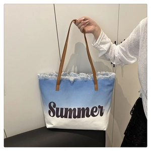 Detail of blue and white gradient canvas tote bag featuring Summer print and frayed edges