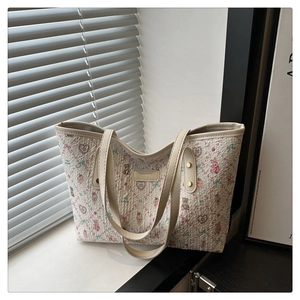 Close-up of quilted fabric tote bag with cute cartoon prints and leather handle