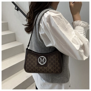 Detail of vintage monogram shoulder bag with metallic M-logo buckle and leather strap