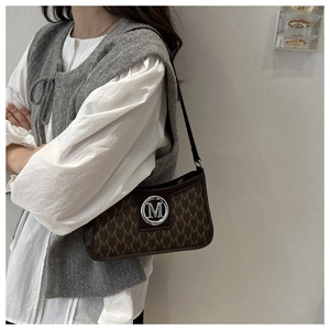 Detail of vintage brown monogram shoulder bag featuring a silver circular M-logo buckle