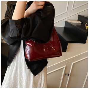 Deep red glossy patent leather baguette bag styled with elegant workplace outfit