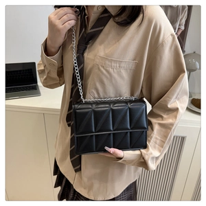 Vue latérale du sac à bandoulière matelassé noir avec chaîne argentée sur modèle
