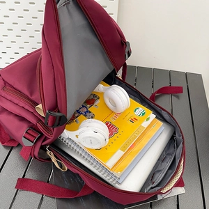 Large burgundy nylon backpack with laptop compartment and spacious storage for students