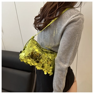 Detail of neon green sequin shoulder bag worn underarm in a Y2K fashion style
