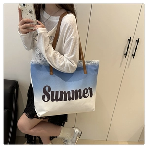 Detail of blue gradient canvas tote with Summer print, fringe edges and brown leather handles