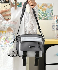 Gray and white nylon crossbody bag with octopus charm shown in a lifestyle mirror selfie