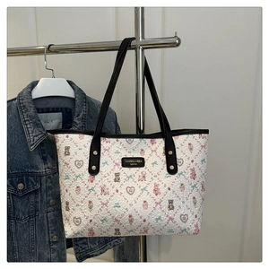 Detailed view of the cute cartoon prints and textured surface of the white tote bag