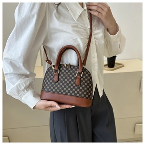 Close-up of geometric pattern crossbody shell bag with brown leather details