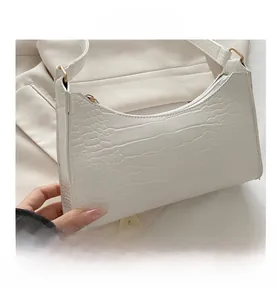 Close-up of white crocodile pattern PU leather with gold hardware and zipper detail