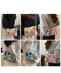 Detail of embroidered floral clutch with sequins and gold metal chain strap