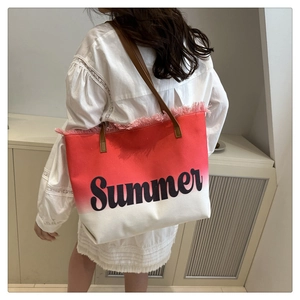 Close-up of red and white gradient canvas tote with Summer print and fringe detail