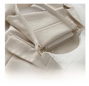 Close-up of white crocodile pattern underarm bag with elegant gold metal ring buckle