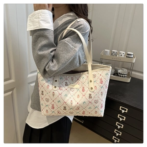 Detail of printed tote bag with cute cartoon motifs and elegant beige shoulder straps