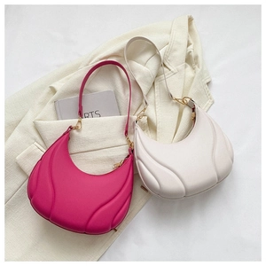 Detail of 3D wave textured leather on pink and beige crescent underarm bags