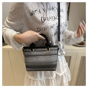 Détail du sac seau tissé avec motifs en dégradé tricolore et anse ronde noire