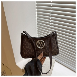 Close-up of brown monogram underarm bag with silver M logo hardware and shoulder strap