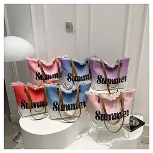 Detail of colorful gradient canvas tote bags with summer print and frayed edges