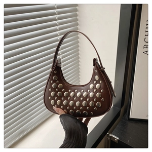 Detailed view of brown crescent bag with silver stud accents and zip closure