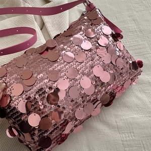 Pink sequin crossbody bag with metallic circular patterns and matching shoulder strap
