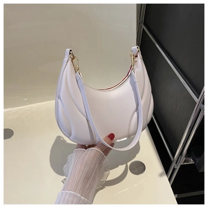 Detail of white pleated faux leather underarm bag with gold buckle and red lining