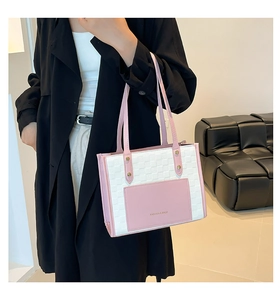 Detail of color-block tote bag with woven white texture and pink pocket on shoulder