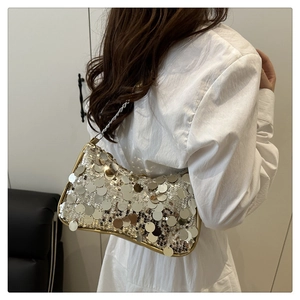 Detailaufnahme der schimmernden Pailletten-Schultertasche mit silberner Kette am Modell