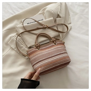 Gros plan du sac seau ethnique tissé avec poignée en cuir sur fond de blazer beige