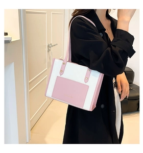 Side view of white and pink leather tote bag with gold logo on a female model