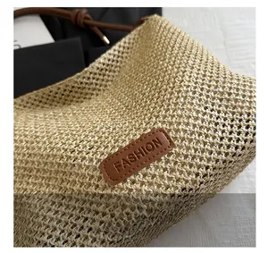 Dettaglio della trama intrecciata e della toppa in pelle marrone con scritta sulla borsa