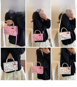Detail showing pink and white cherry pattern small crossbody bags with woven handles