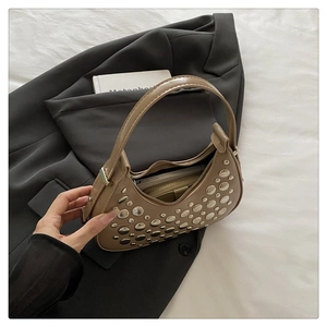 Detail of khaki crescent bag with silver rivets showing interior storage capacity